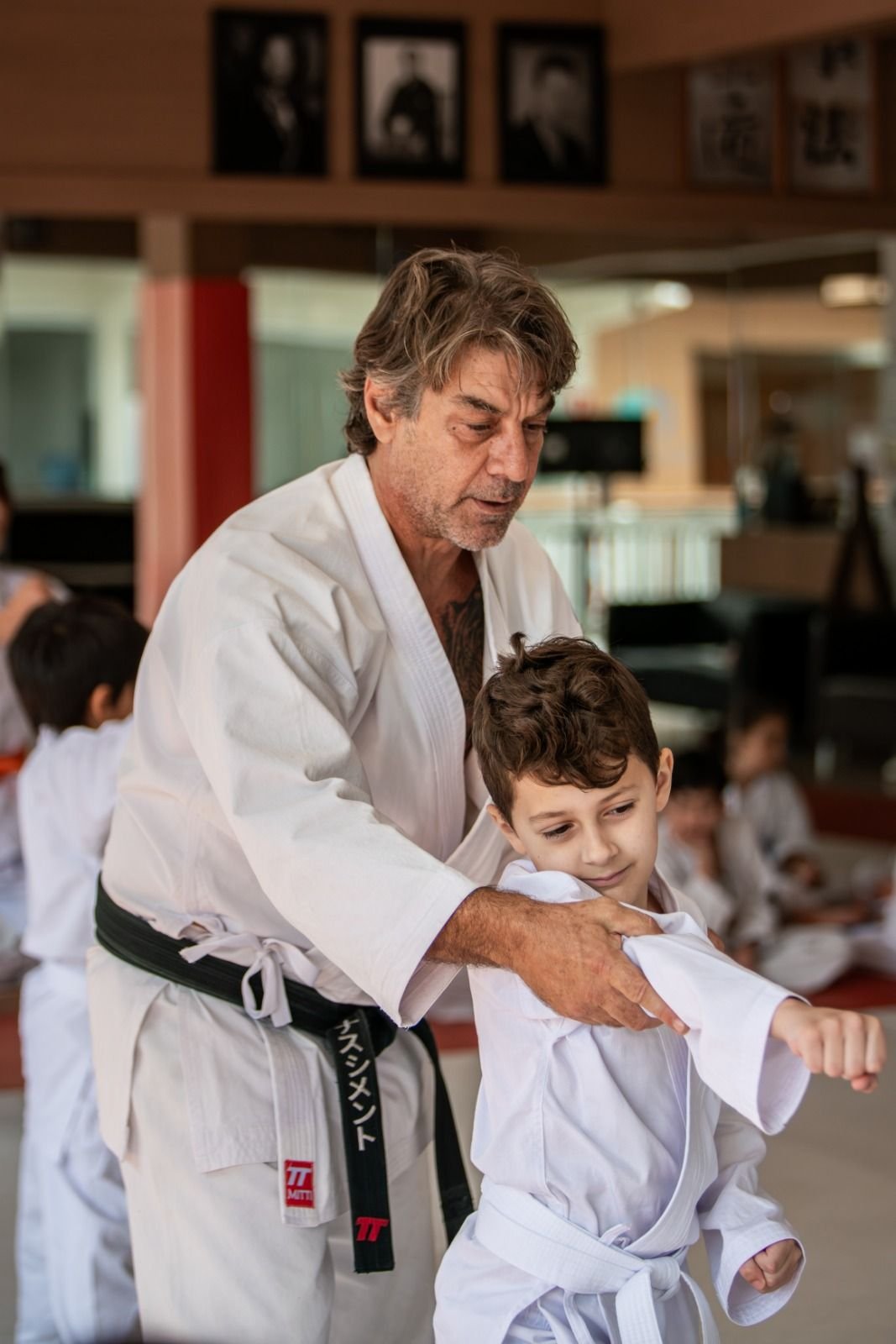 Sensei Roberto Nascimento corrige a posição do braço de um aluno durante a aula